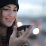 Voice Search Optimization - Joyful young woman phoning on street in evening
