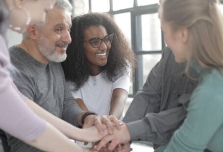 CRM Integration - Content multiethnic colleagues joining hands after coming to agreement