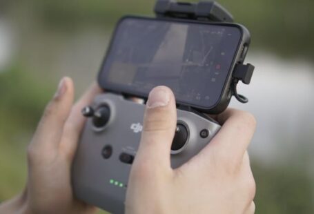 Touchscreen Compatibility - Guy flying a drone shwoing controller holding iphone dji