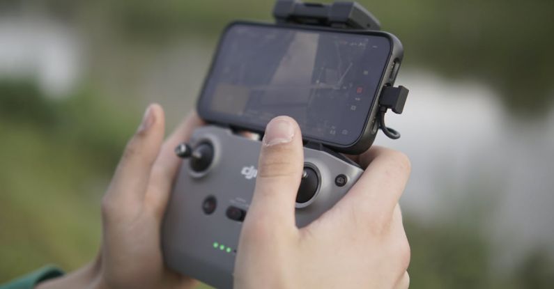 Touchscreen Compatibility - Guy flying a drone shwoing controller holding iphone dji
