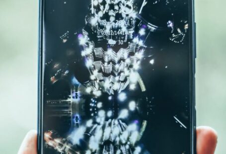 Progressive Web Apps - Crop person hand holding modern mobile phone with various apps and illuminated city on wallpaper